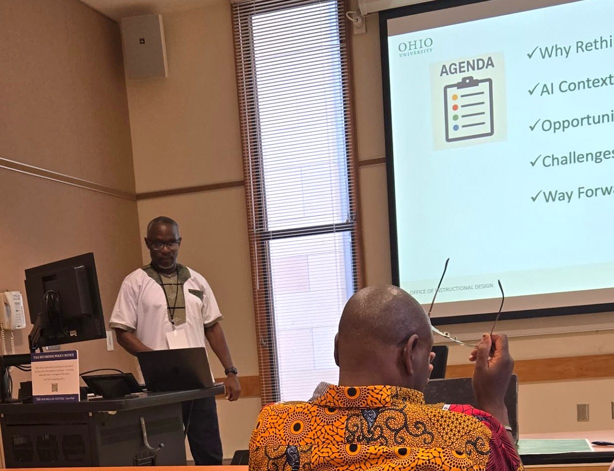 Patrick Mose presenting at the podium beside the workshop agenda slide