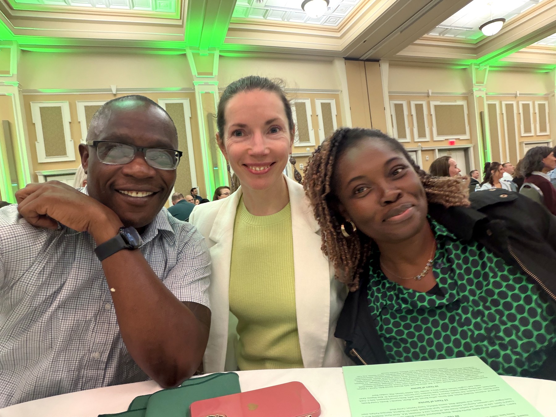 Patrick Mose smiling alongside two colleagues at a professional awards banquet